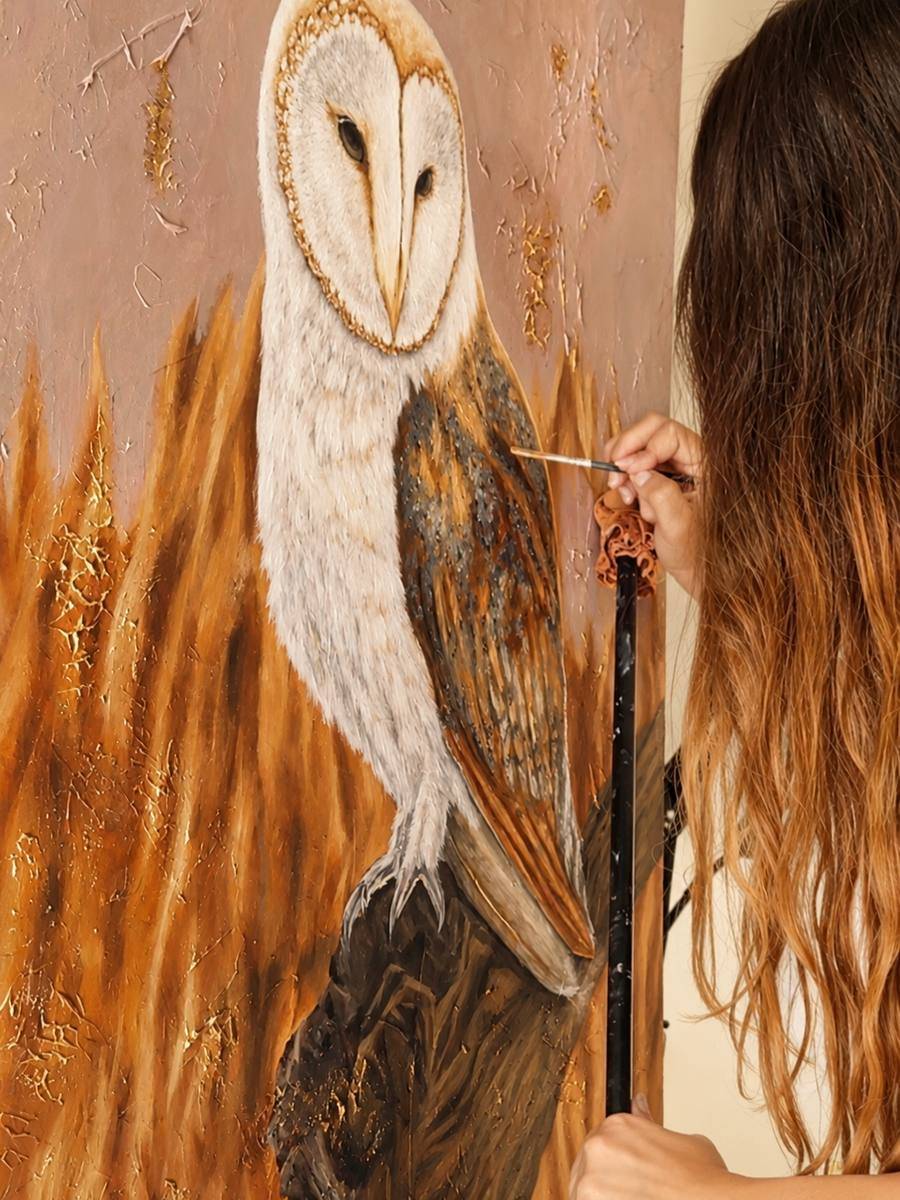 Sultana A. Sultan painting an owl in oil on wood panel